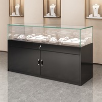 Vitrine de luxe en verre trempé noir mat sur pied pour salon professionnel, présentoir à bijoux avec éclairage LED et rangement
