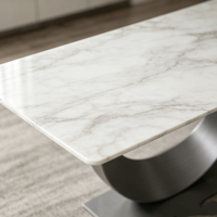 Table à manger rectangulaire minimaliste italienne en pierre frittée avec base incurvée en acier inoxydable brossé, mobilier de maison robuste