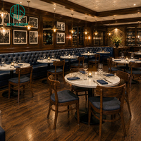 Ensemble de mobilier de restaurant Ron Group : banquette en cuir capitonnée en forme de L, chaises rembourrées en bois, table ronde en marbre et banquette.