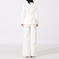 Ensemble deux pièces automne 2026 pour femme : haut à col en V et manches longues avec appliques et poches, et pantalon taille haute