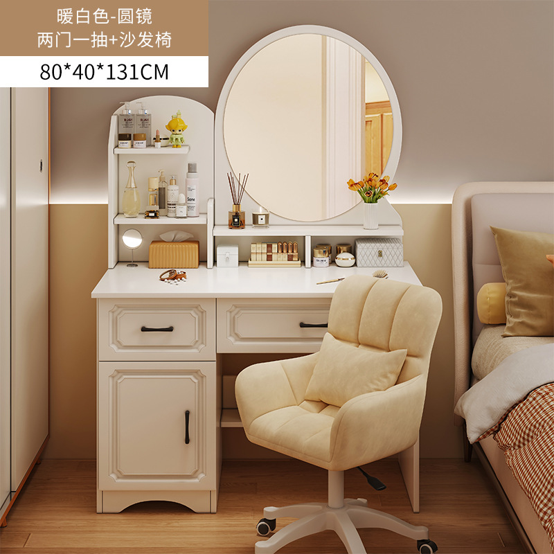 Espejo redondo, dos cajones, una puerta, sillón con forma de pétalo.