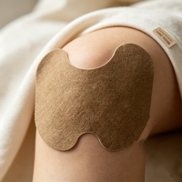 Patch ergonomique en forme de genou à infrarouge lointain pour soulagement aux herbes, pansement corporel non tissé marron avec pansement aux herbes noires, ODM OEM disponible