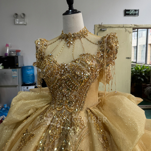 Robe de bal de Quinceañera de luxe Mc029 en tulle doré, longueur ras du sol, richement perlée et scintillante, avec traîne chapelle, volants latéraux drapés et dos en dentelle - Product Image 2