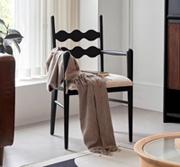 Fauteuil de salle à manger en bois massif noir avec dossier ondulé et coussin en cuir blanc, design moderne pour la maison