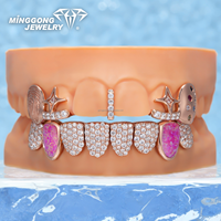 Grillz ouverts personnalisés plaqués or rose et argent, avec détails empreinte digitale, accents de pierres précieuses colorées, pierres latérales en opale rose, et partie inférieure entièrement pavée de pierres.