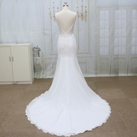 Robe de mariée sirène de luxe moderne, longueur ras du sol, bretelles spaghetti, dos illusion, détails boutonnés, appliques en dentelle perlée, lavable