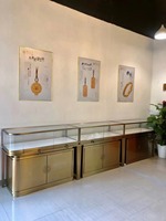 Vitrine de magasin de bijoux personnalisée en acier inoxydable, bois et verre avec un design tendance pour l'affichage de colliers, boucles d'oreilles et bagues