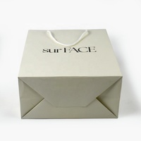 Sac de shopping en carton blanc épais de luxe avec logo personnalisé pour l'emballage de vêtements, de cosmétiques et de cadeaux
