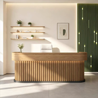 Bureau d'accueil moderne en bois à lattes avec comptoir anthracite et lettres dorées lumineuses à LED pour hall d'hôtel ou bureau