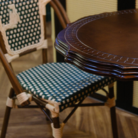 Table de bistrot vintage de style parisien, plateau rond en bois festonné avec base en fonte.