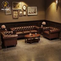 Ensemble de mobilier de salon commercial en cuir ciré vintage, fauteuil capitonné en losange et canapé avec tables de bistrot en bois massif