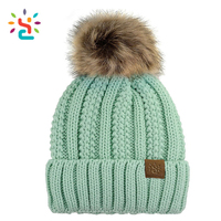 Modische Damen Dicke Zopfmuster-Strickmütze mit Kunstfell-Bommel, Wintermütze mit Umschlagrand, Anpassbares Logo, Leder-Patch-Beanie