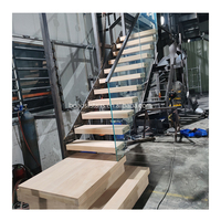 Escaliers flottants d'intérieur modernes avec grande plate-forme en bois et balustrade en verre pour appartement au design contemporain