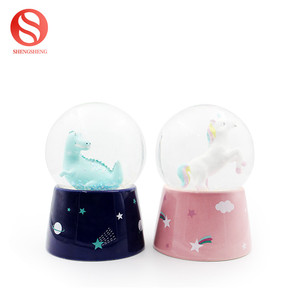 Personnalisé tyrannosaure écologique enfant cadeau LED lumière musique rotation neige céramique dinosaure boule à neige - Product Image 4