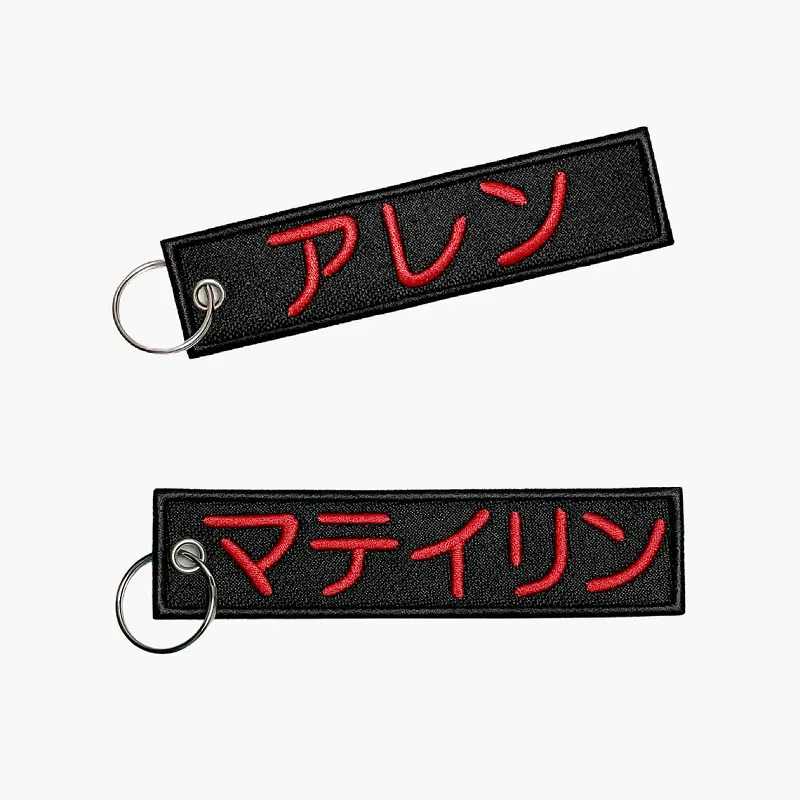 Venta caliente promocional logotipo personalizado tejido Jet tag negro bordado tela llavero para coche