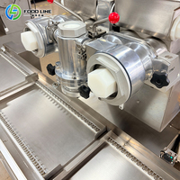 Machine à encruster à décharge automatique pour la production de pâtisseries fourrées