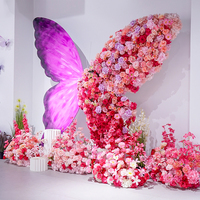 Décor de scène de mariage avec arrière-plan de fleurs artificielles géantes en métal moderne et luxueux, arrangement floral rose avec papillons