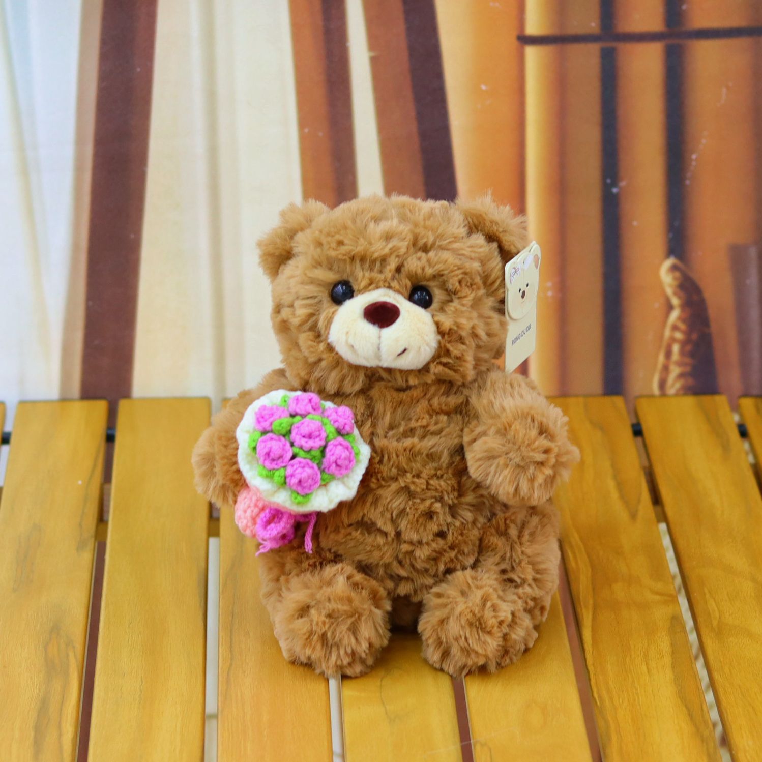 ours brun avec bouquet de fleurs roses