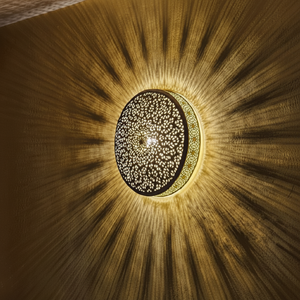 Applique murale ronde en laiton perforé marocaine coulée d'intenses motifs d'ombres sunburst à travers le mur. - Product Image 1