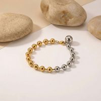 Bracelet minimaliste en acier inoxydable avec perles, orné d'un mélange de sphères polies or et argent et d'un fermoir mousqueton
