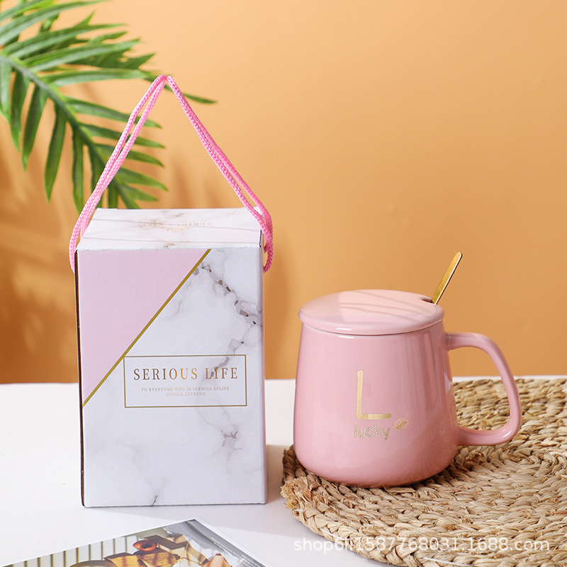 Taza térmica rosa con tapa y cuchara.