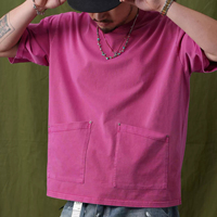 T-shirt en coton épais à col ras du cou, coupe ample, délavage pigmenté, avec double poches inférieures, épaules tombantes et rivets métalliques