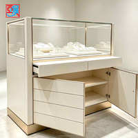 Comptoir de présentation de bijoux blanc crème avec tiroirs et armoire de rangement, vitrine à bijoux en verre avec finition dorée pour boutique de diamants