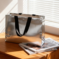 Sacs shopping en papier argenté métallisé de luxe personnalisés avec poignées en ruban noir pour l'emballage de vêtements, de cadeaux et de vente au détail