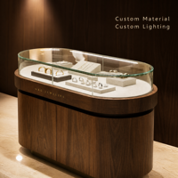 Vitrine de présentation de bijoux ovale sur mesure avec verre incurvé pour les magasins de bijoux en chaîne, taille, couleur, éclairage et matériaux personnalisés