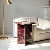 Table basse élégante en marbre scandinave bordeaux, sculpturale avec cadre en X, accent en pierre rouge profond, mobilier haut de gamme pour salon