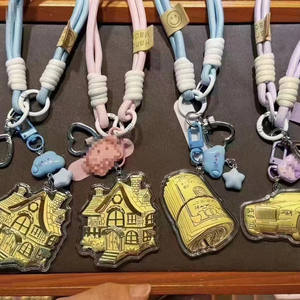 Llavero con correa de cuero y oro genuino de 24K, presentado con detalles decorativos de metal con motivos de dibujos animados. - Product Image 2