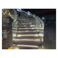 Escalier courbé à quart de tour avec marches en érable et poutre intérieure métallique, conception gain de place pour entrée d'appartement