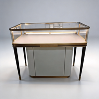 Vitrine de présentation de bijoux de luxe blanc laiteux, table en verre et métal or et noir avec éclairage LED pour mobilier de boutique de détail