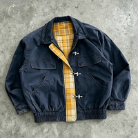 Blouson bomber Ouna personnalisé en tissu sergé délavé, avec empiècements à carreaux jaunes, style vintage pompier, et fermeture à bouton et mousqueton.