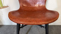 Chaise rétro en PU à prix d'usine avec dossier cintrée à surpiqûres contrastées et pieds en métal noir robustes pour bistrot et cuisine (vente en gros)
