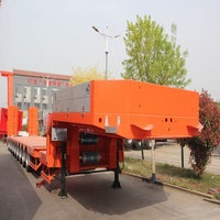 Semi-remorque à plateau surbaissé à 3 essieux, couleur rouge, avec essieux à direction automatique, rampes hydrauliques ajoutées