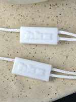 Étiquettes suspendues personnalisées en papier argenté métallisé deux pièces avec logo en relief, scellés en plastique et cordon ciré pour l'emballage de marques de vêtements