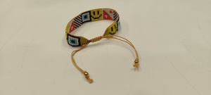 Bracelet artisanal Sstringz en perles Miyuki Delica multicolores avec motif visage souriant jaune, motif œil bleu et motif à carreaux noir et blanc - Product Image 2