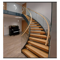 Escalier en colimaçon courbé sur mesure avec marches en acajou, balustres en fer forgé et main courante en laiton poli