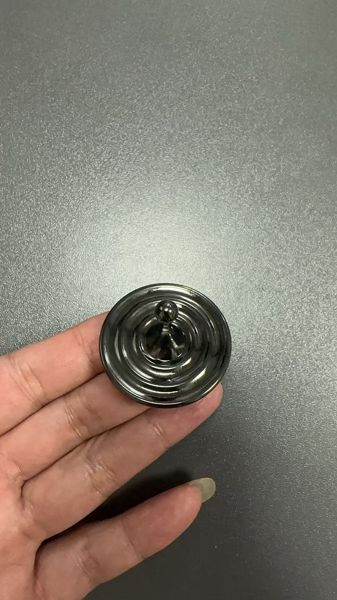 Spinner antiestrés con forma de gota de agua negra.