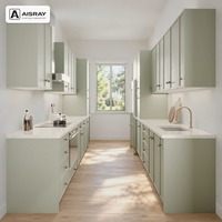 Meuble de cuisine en PVC style Shaker pour configuration en U, avec portes à cadre fin vert sauge, boîtes en panneaux mélaminés et boutons ronds
