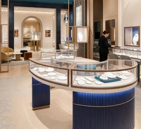 Vitrine à bijoux incurvée de luxe, bleu marine, base cannelée, cadre en métal rose gold |   Vitrine en verre avec éclairage LED |   Personnalisable