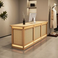 Comptoir d'accueil minimaliste moderne en MDF personnalisé avec panneau en rotin PVC, éclairage LED ambiant octogonal encastré, pour boutique de vêtements