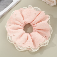 Bandeau pour cheveux avec dentelle ajourée en forme de cœur et cordon à franges pour une coiffure chignon douce et charmante.