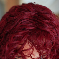 Peluca de Cabello Sintético Largo y Rizado Rojo Brillante de 22 Pulgadas con Flequillo, Fibra Resistente al Calor, Aspecto Natural Mate