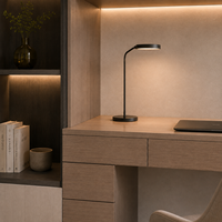 Armoires de bureau avec rangements en chêne clair, un mur de bureau gris et des étagères ouvertes éclairées