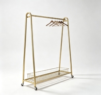 Porte-vêtements roulant en métal doré en forme de A avec panier inférieur en fil métallique et dessus arqué lisse pour boutique éphémère
