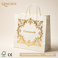 Sacs shopping en papier crème OEM personnalisés avec logo encadré ornemental, impression feuille d'or et poignées en corde torsadée pour boutiques et commerces de détail