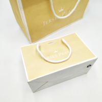 Bolsa de regalo de papel laminado al por mayor con asa de cinta y logotipo impreso personalizado para embalaje de joyería, ropa y calzado.