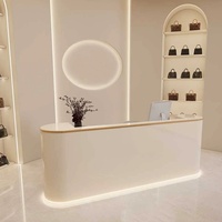 Comptoir de réception moderne en beige clair avec éclairage LED, comptoir de caisse minimaliste, boutique de sacs à main de luxe, vente au détail de mode, hôpital